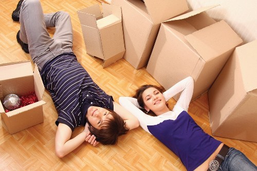 Boxes and furniture being carried through a London apartment entrance