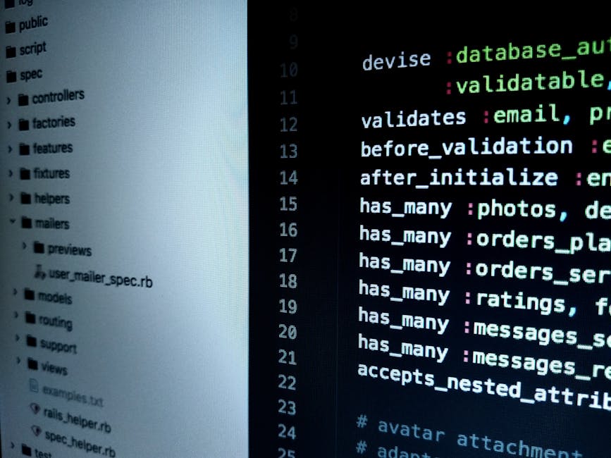 A person's hand with a wristwatch resting on a silver laptop keyboard, which is open on a wooden surface. The laptop screen displays lines of code or text in a dark-themed editor. The scene appears to